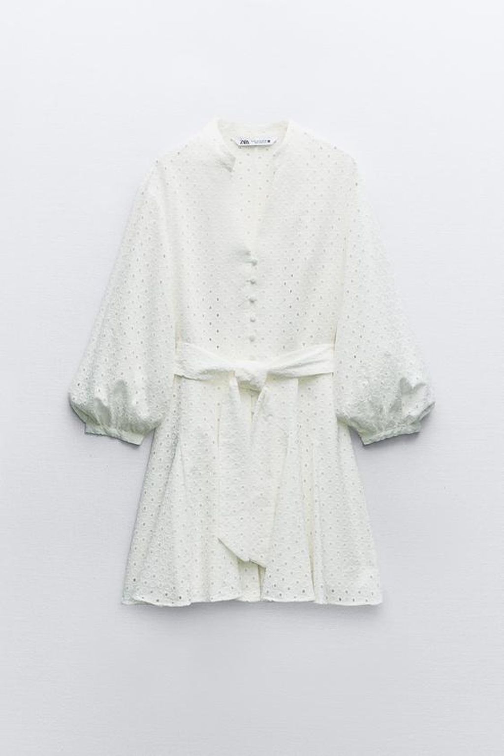 Vestido blanco troquelado con manga media, de Zara
