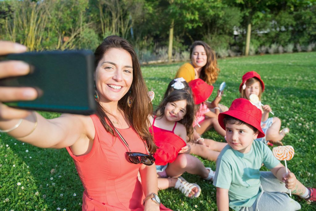 Mujer fotografiándose junto a unos niños