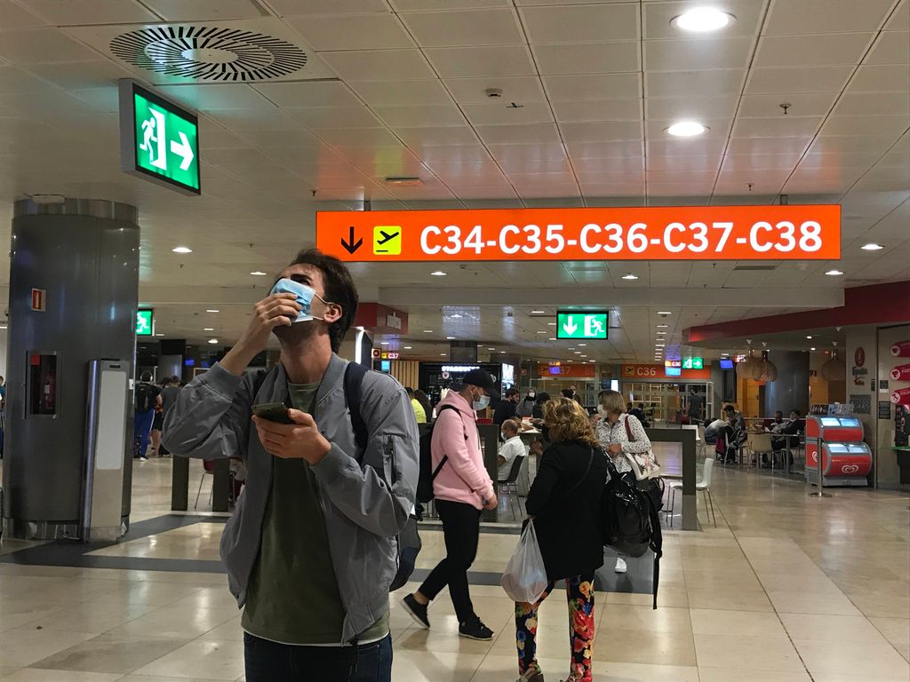 UN JOVEN BUSCA SU VUELO EN LAS PANTALLAS