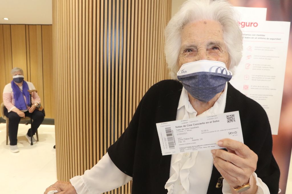 Señora con la entrada en la mano.