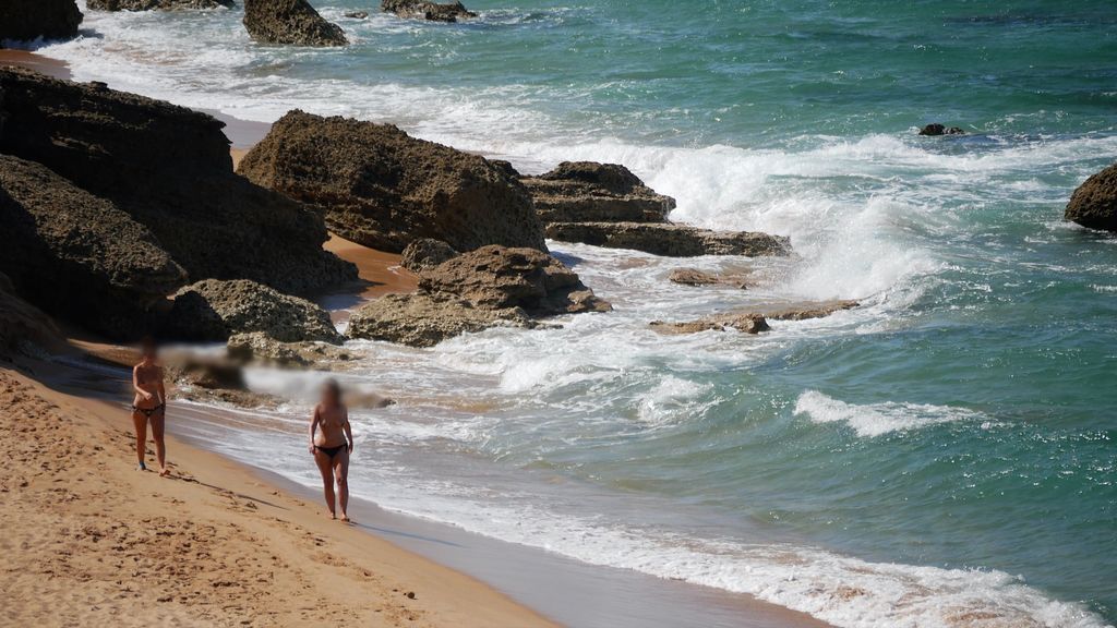 Dos mujeres pasean, sin mascarilla, por una cala de Conil de la Frontera