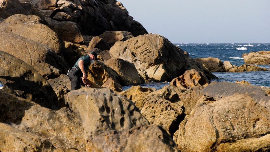 Un Guardia Civil buscando entre las rocas