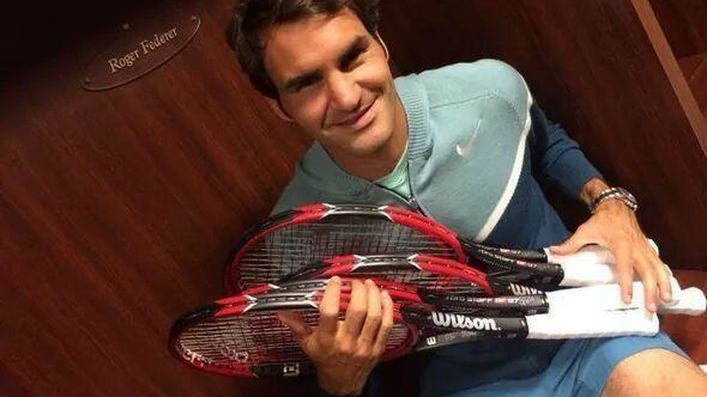 Roger Federer posando con sus raquetas de tenis