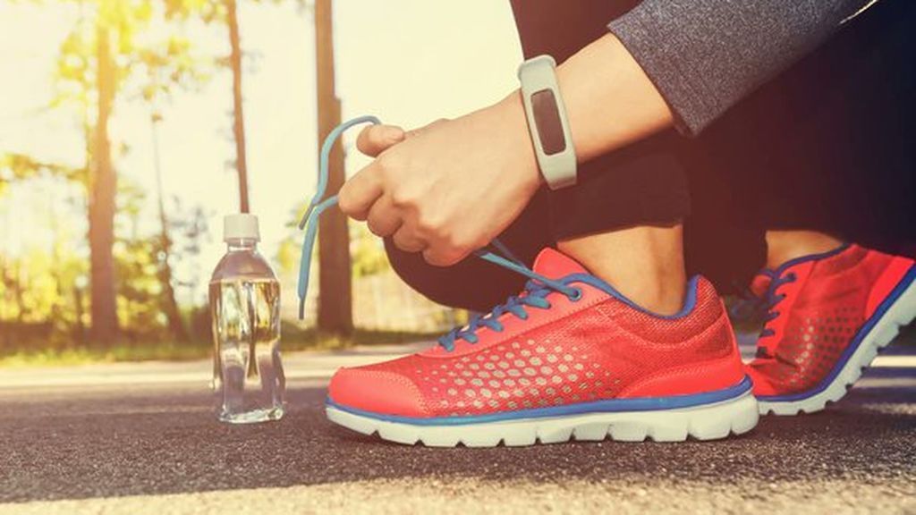 persona atando los cordones de unas zapatillas para correr