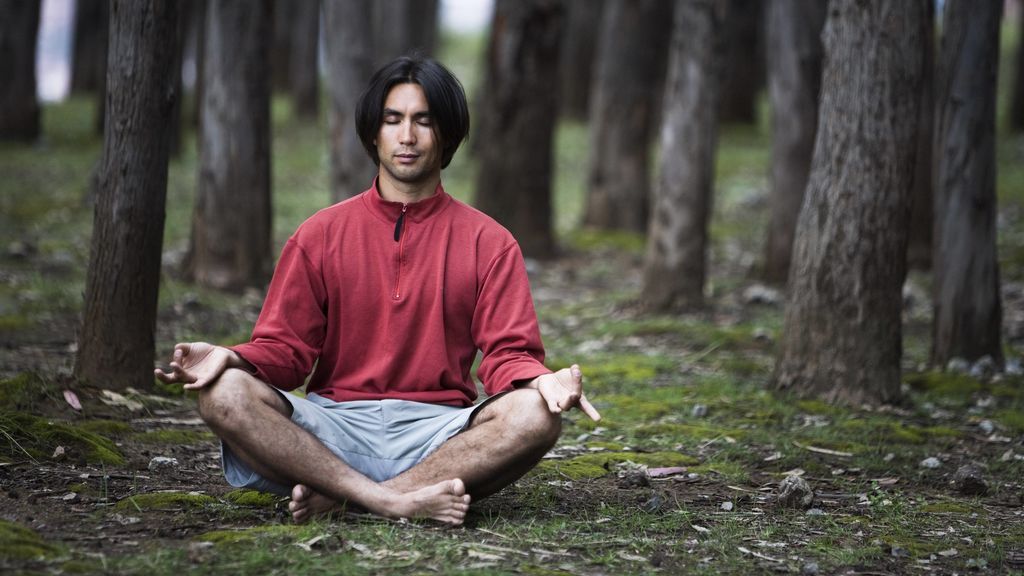 persona practicando mantras de yoga en el bosque