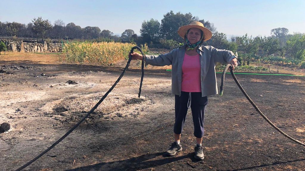 Angelita, en su finca, con los cultivos que se han salvado del fuego al fondo