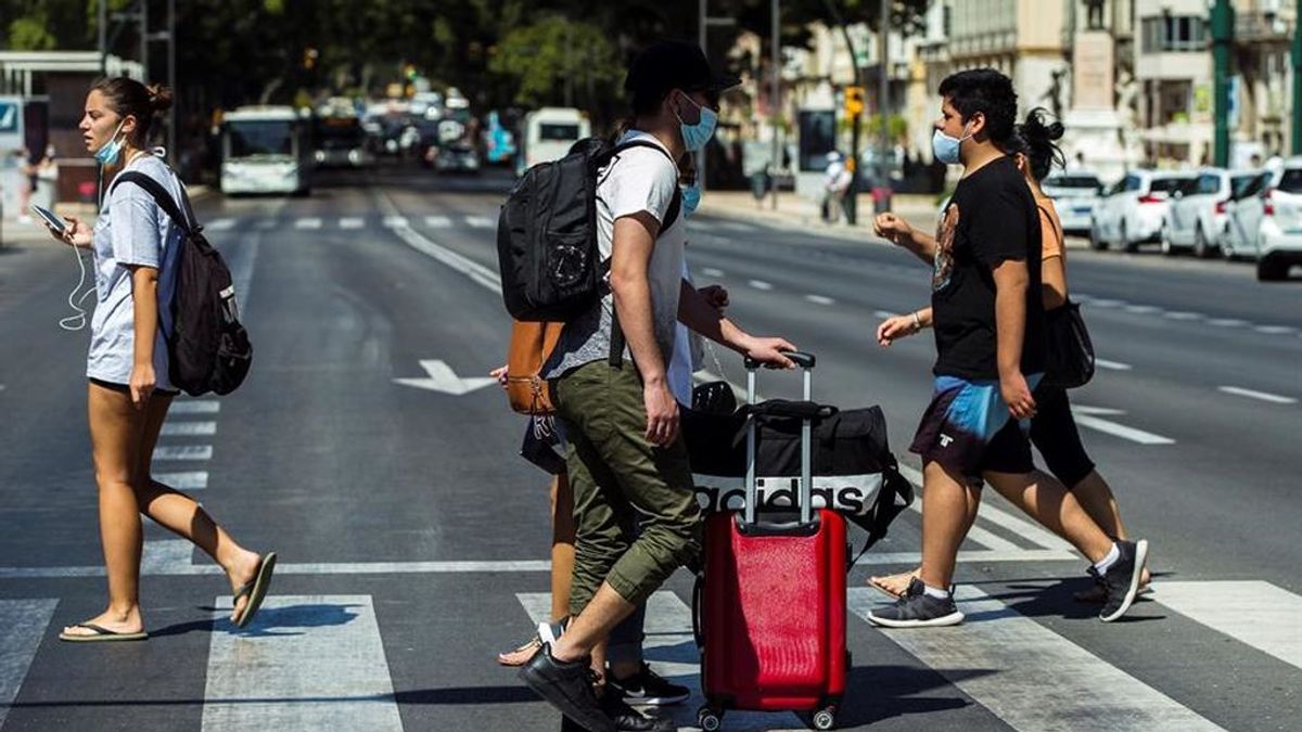 Varios turistas con maletas caminan por el centro de Málaga