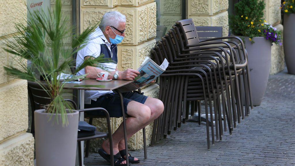 Un hombre con mascarilla lee un periódico durante la pandemia de coronavirus en Italia