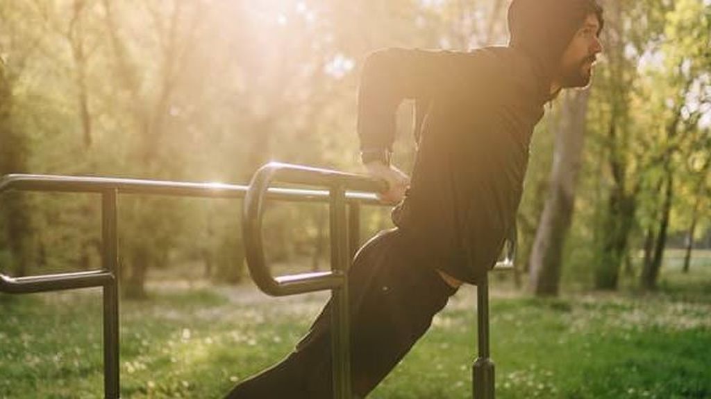 hombre entrenando calistenia en un parque de barras