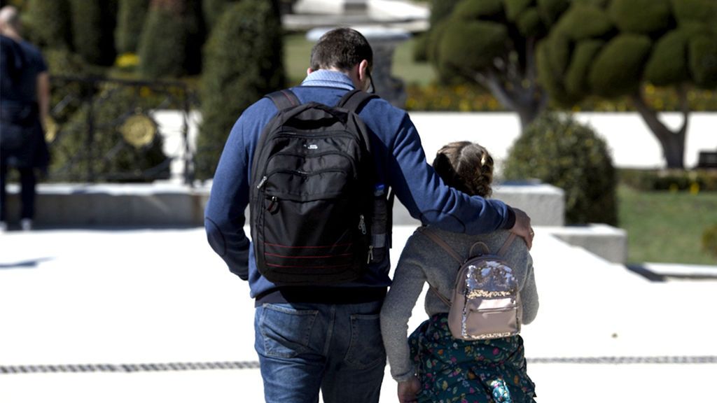 Un padre y su hija caminan al colegio