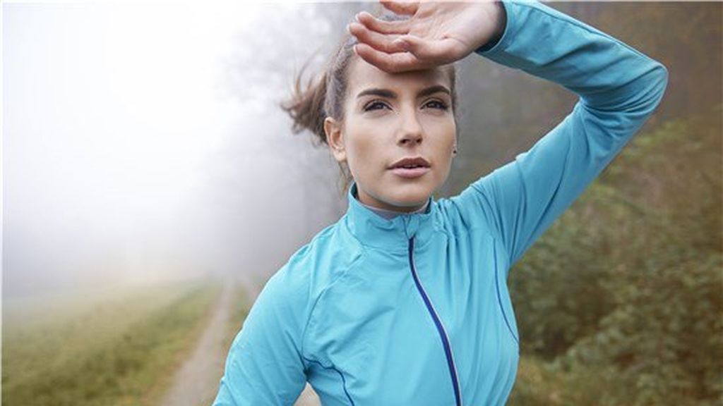 mujer corriendo por el bosque en invierno