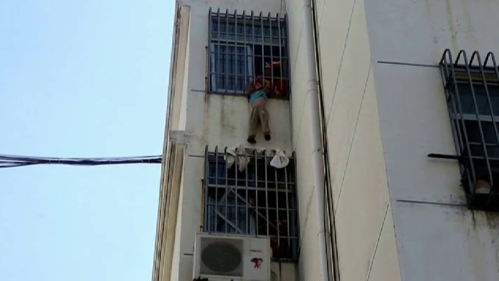Angustioso rescate de los bomberos a un niño colgado en un quinto piso en China
