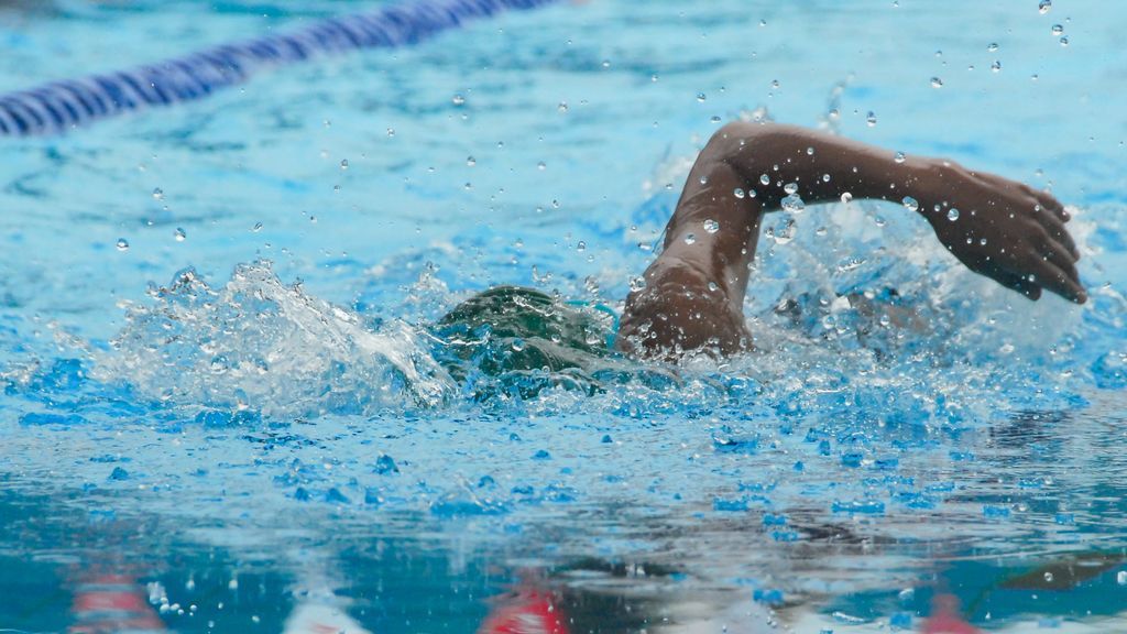 Persona nadando en una piscina.