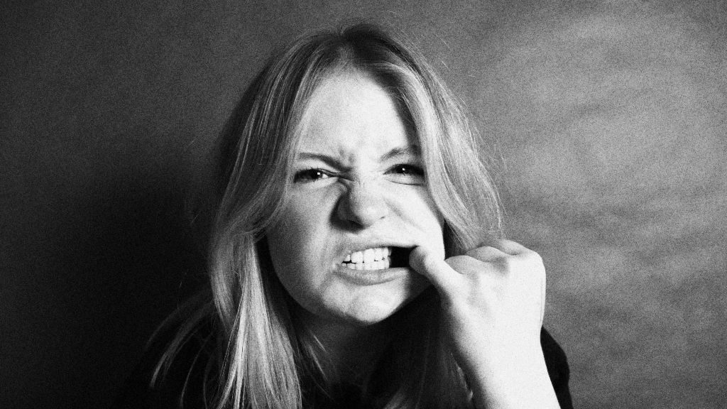 Una chica tocándose compulsivamente los dientes y la boca