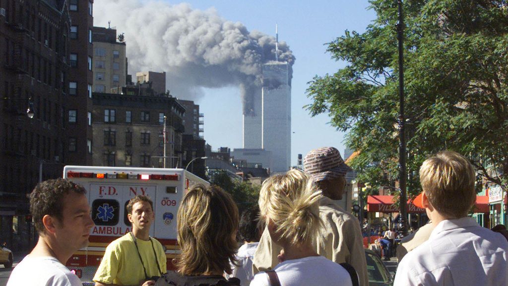 La gente observa las columnas de humo de las dos torres del World Trade Center.