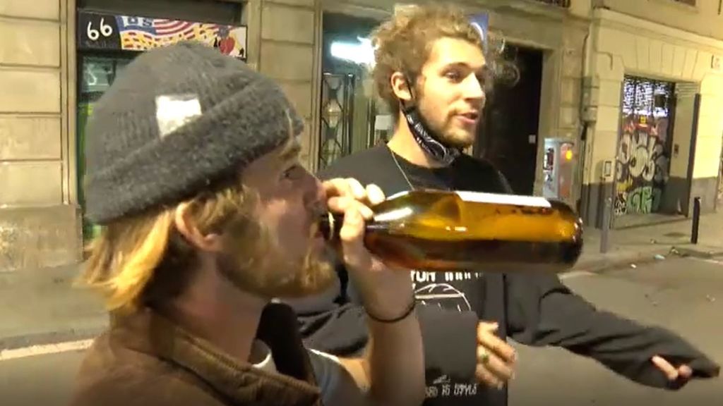 Turistas extranjeros intentan evitar que les graben bebiendo en la calle sin mascarilla ni distancia de seguridad en Barcelona