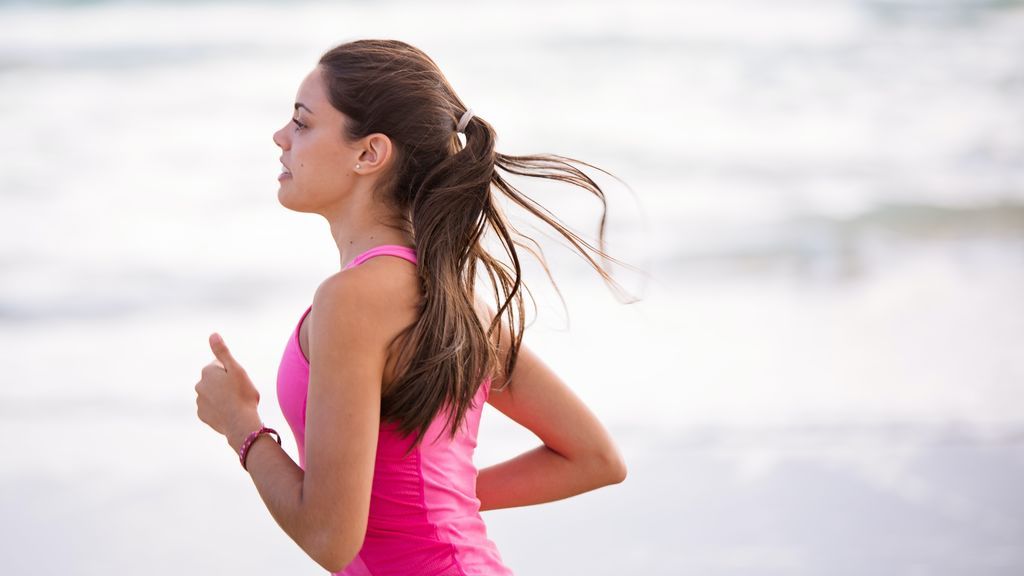 Mujer corriendo por la playa.