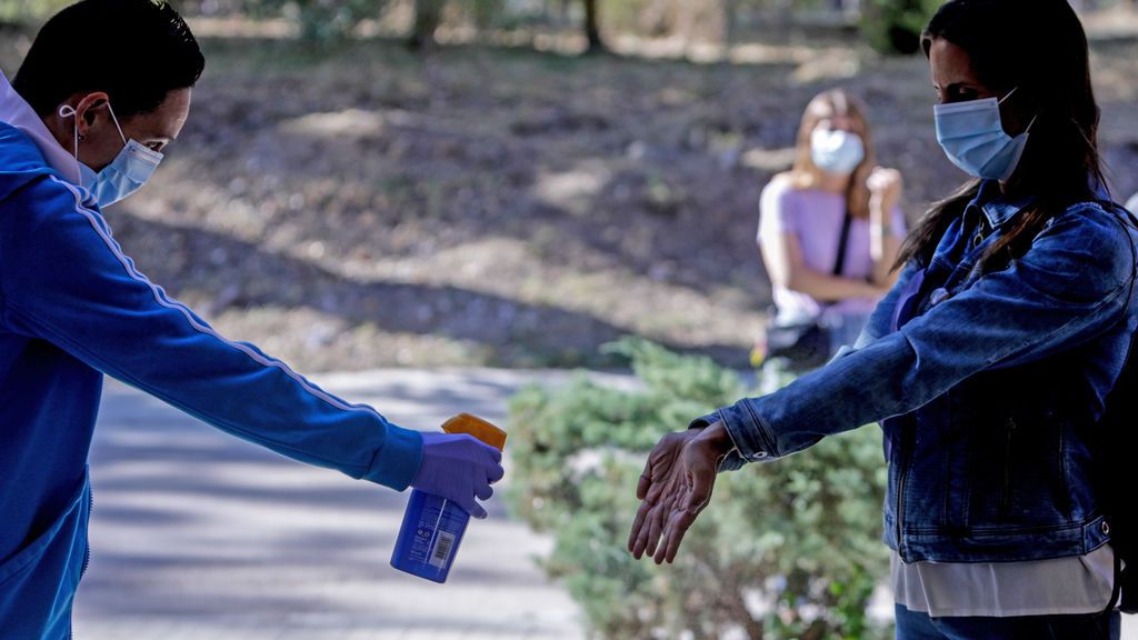 Un sanitario administra desinfectante a una mujer