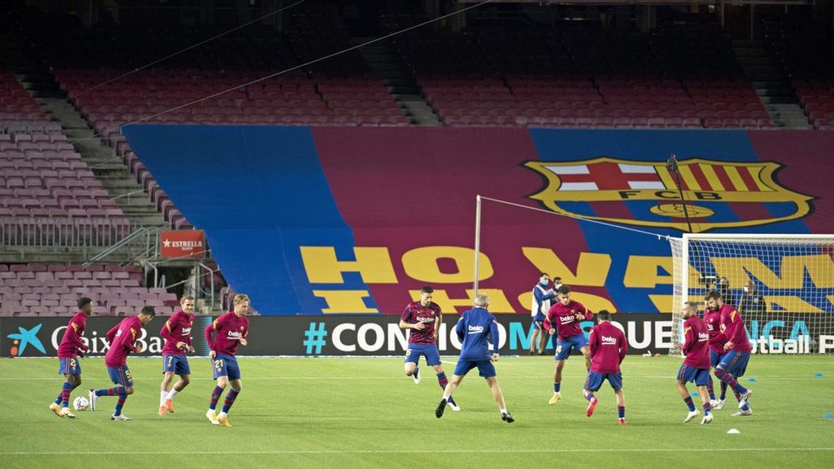 Los jugadores del Barcelona calientan antes de un partido en un Camp Nou vacío.
