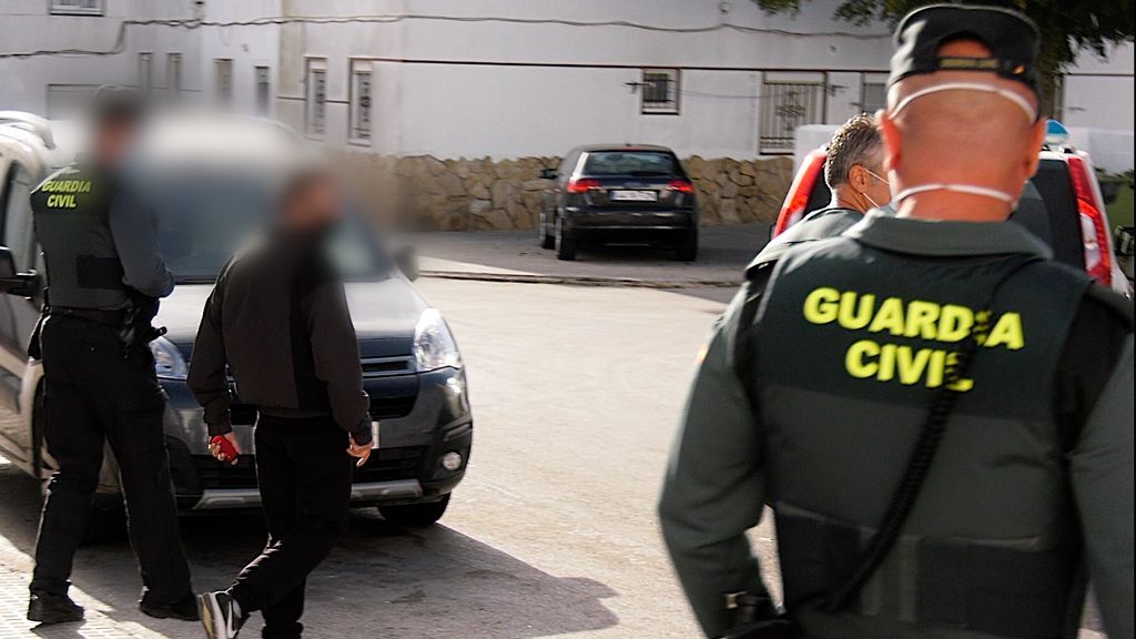 Dos guardias civiles flanquean a uno de los detenidos