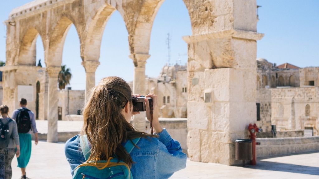 Una chica fotografiando el patrimonio monumental de Israel