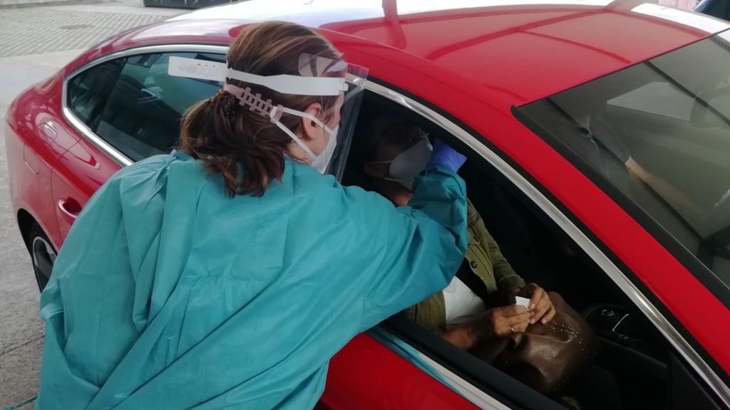 Una sanitaria toma una muestra a una mujer en un autocovid Una sanitaria toma una muestra a una mujer en un autocovid