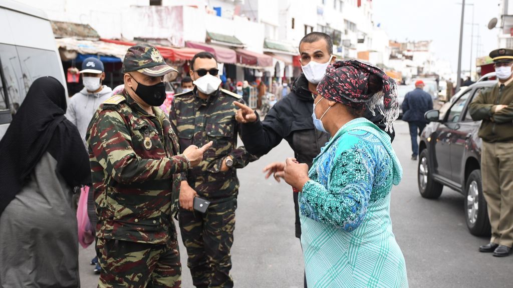 Miembros de las fuerzas de seguridad junto a otras personas con mascarilla en Rabat, Marruecos