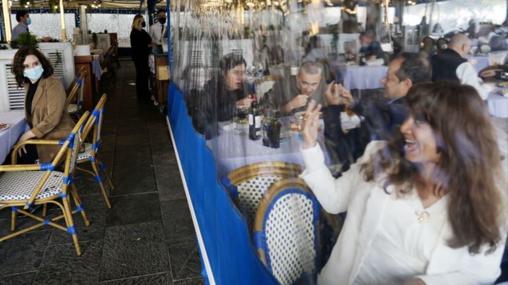 Una vecina saluda a la presidenta de Madrid en una terraza de Barcelona