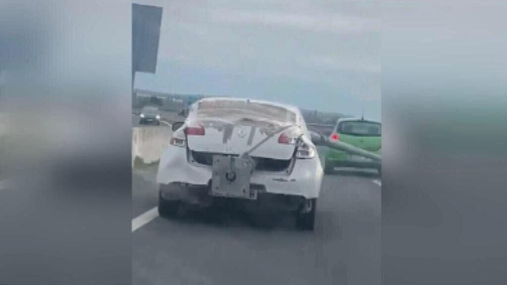 Un coche circula cargado con una farola en la autovía de Cádiz