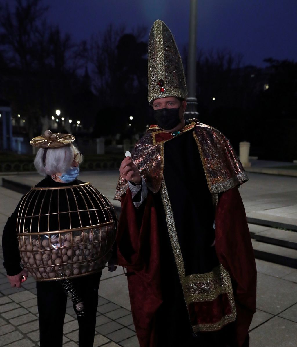 Dos entusiastas del Sorteo de Navidad disfrazados aguardan en las inmediaciones del Teatro Real