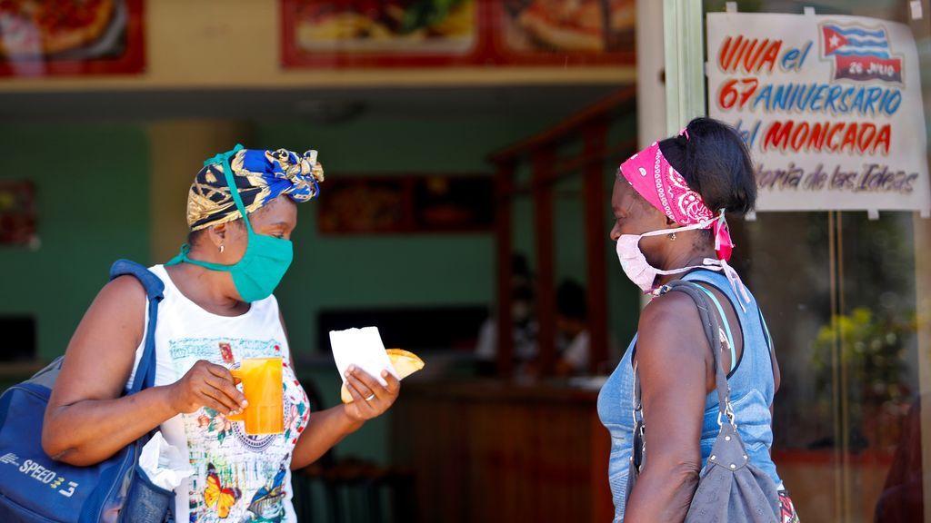 Dos mujeres protegidas con mascarilla hablan en una cafetería, en La Habana, (Cuba)