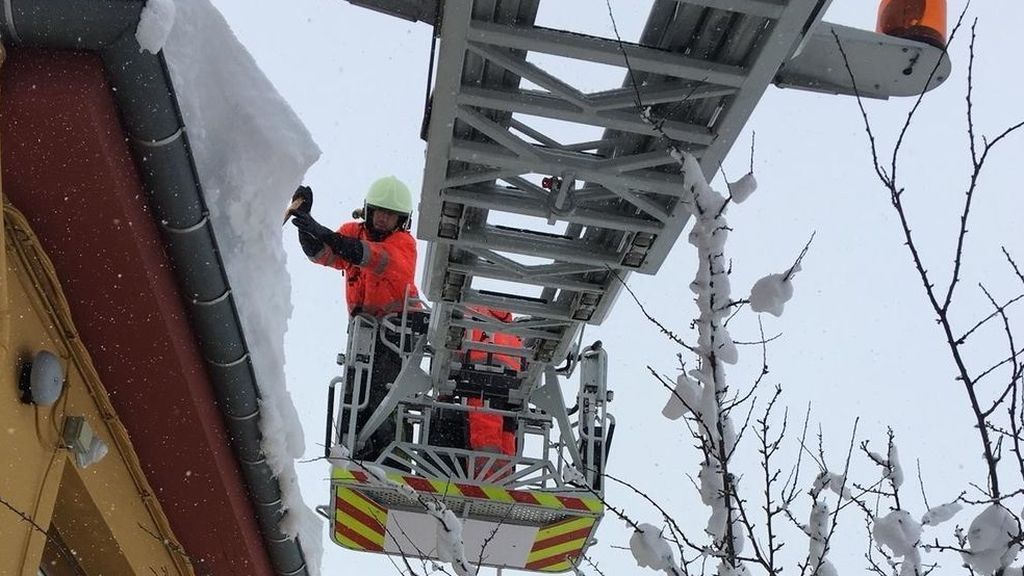 Bomberos retiran la nieve de los tejados