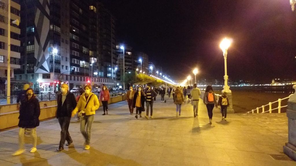 Vecinos de Gijón paseando por el Muro de San Lorenzo