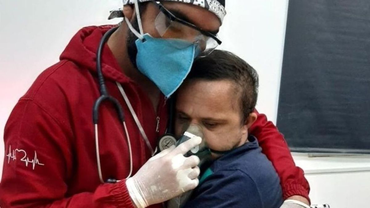 La tierna imagen de un enfermero brasileño calmando a un paciente covid con síndrome de Down
