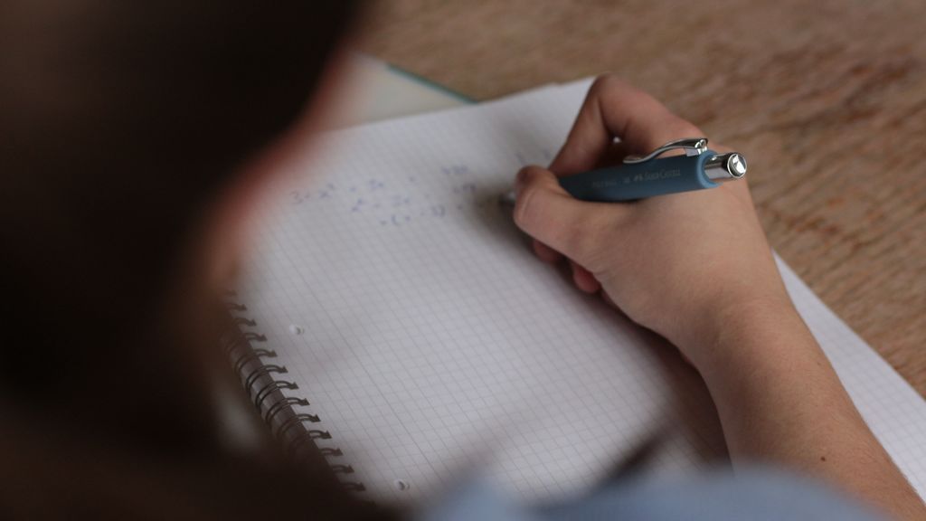 Un chico en clase escribiendo