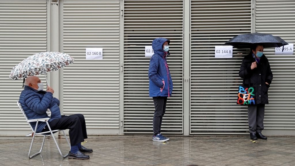 Varios votantes hacen cola en uno de los colegios electorales del Mercat de Sant Antoni de Barcelona