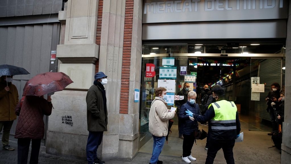 Varias personas hacen cola para votar en el colegio electoral situado en el Mercat del Ninot