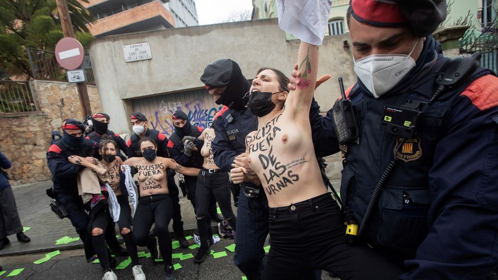 Varias activistas al grito de “Vota Garriga, vota fascista” se manifiestan delante del colegio electoral del cabeza de lista de Vox por Barcelona, Ignacio Garriga