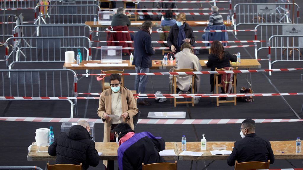 Varias personas votan en el colegio electoral del polideportivo municipal de Palau en Girona