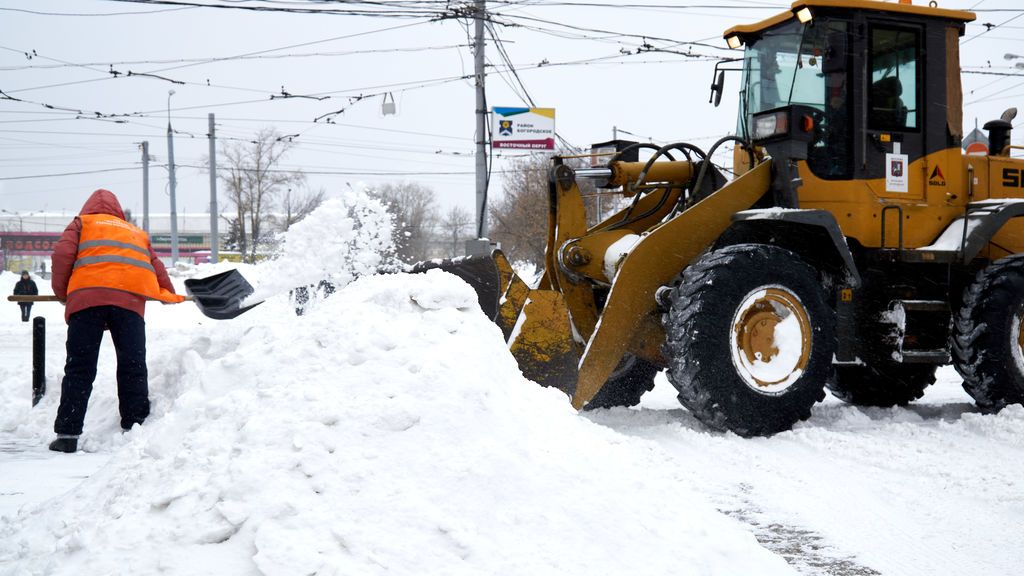 EuropaPress_3561702_13_february_2021_russia_moscow_man_with_shovel_fills_snow_into_tractor_on