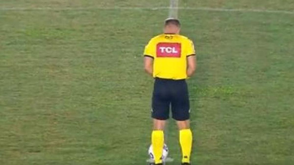 Un árbitro orina en el césped junto al balón antes del pitido inicial de un partido
