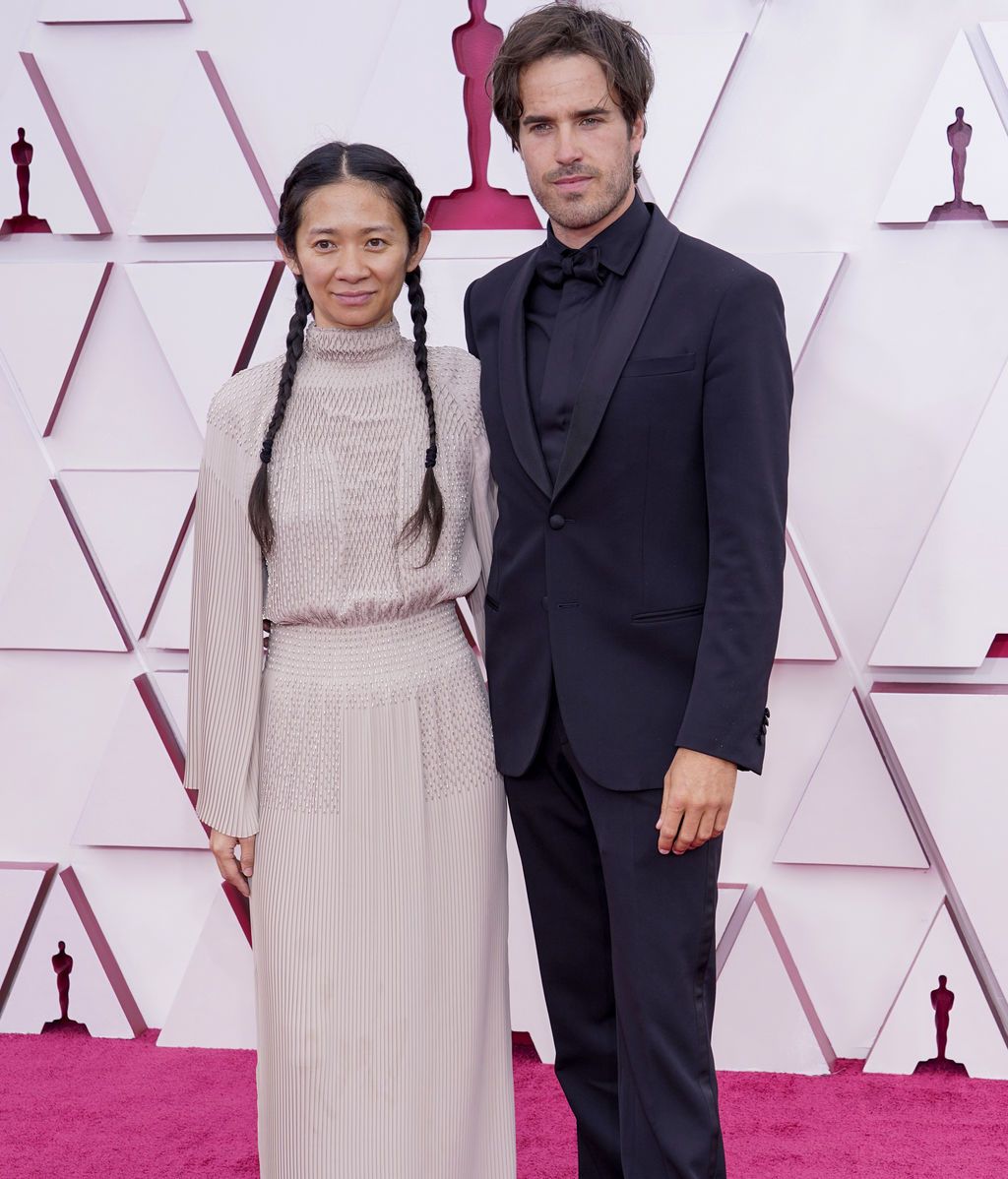 Chloe Zhao y Joshua James Richards desfilan en la alfombra roja de Union Station, la estación de autobuses de Los Ángeles, una de las sedes donde tiene lugar la gala de los Premios Oscars 2021