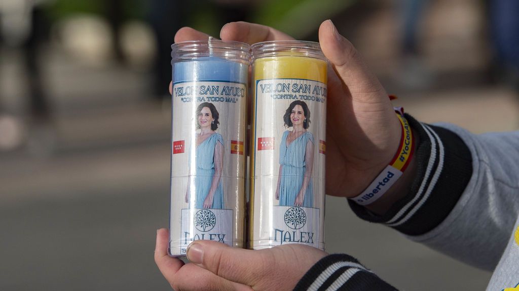 Dos velones con el lema 'San Ayuso' en un acto electoral del PP