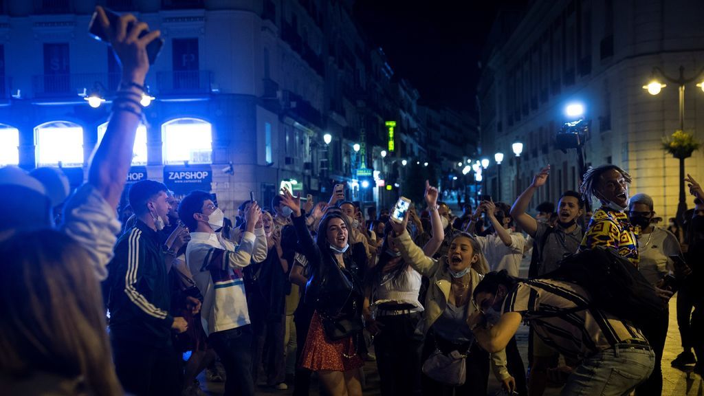 Varios jóvenes celebran en la Puerta del Sol de Madrid el fin del estado de alarma