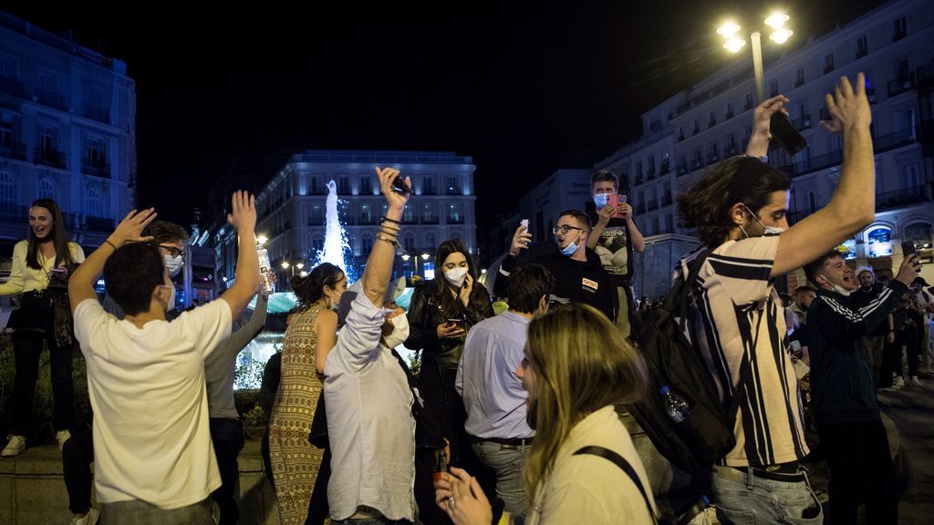 Varios jóvenes celebran en la Puerta del Sol de Madrid el fin del estado de alarma