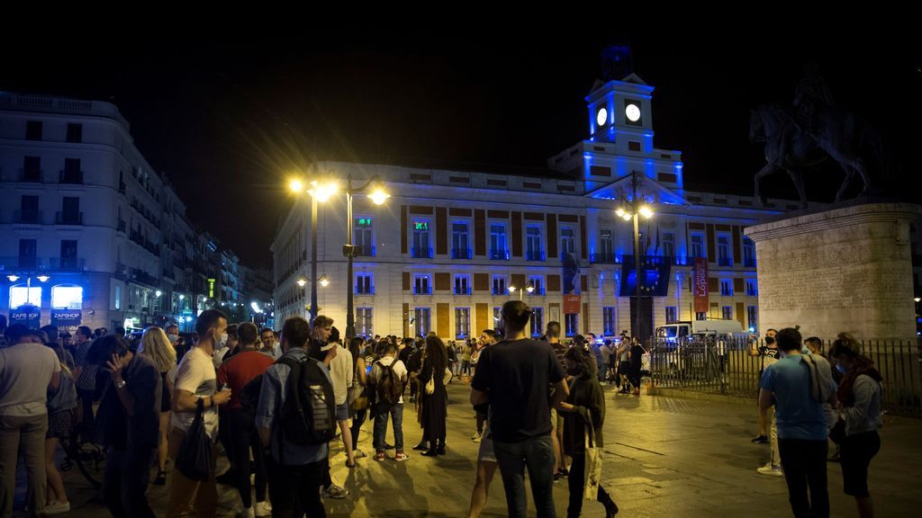 Varios jóvenes celebran en la Puerta del Sol de Madrid el fin del estado de alarma