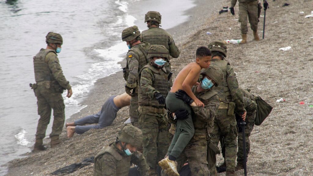 Miembros del Ejército de Tierra ayudan a un grupo de inmigrantes que han logrado cruzar