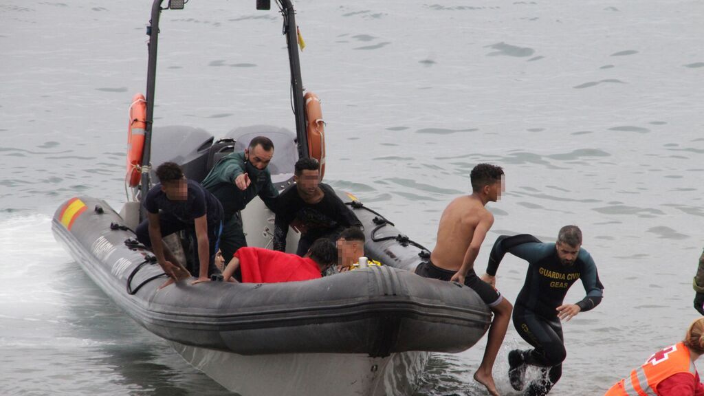 Miembros de la Guardia Civil y la Cruz Roja ayudan a un grupo de inmigrantes que han logrado cruzar