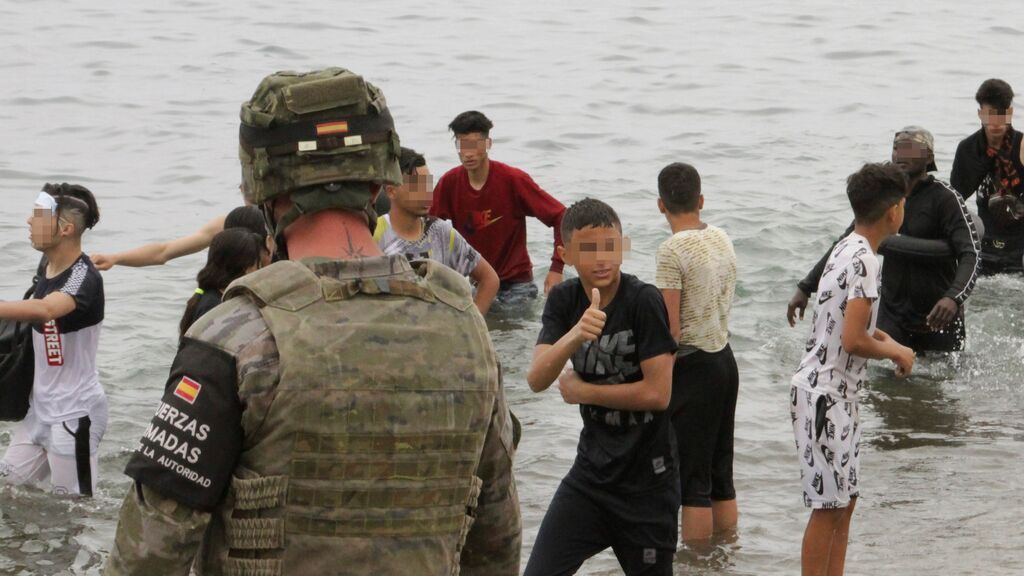 iembros del Ejército de Tierra vigilan a un grupo de inmigrantes menores