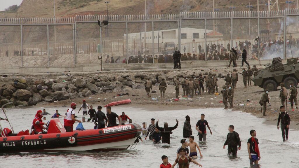 Miembros de la Cruz Roja ayudan a un grupo de inmigrantes menores que han logrado cruzar